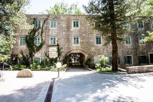a large stone building with a gate and a tree at Beach Side Holiday in Omiš