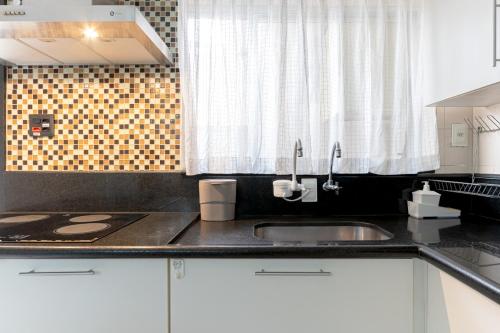 a kitchen counter with a sink and a window at Tatuapé , garagem e ar condicionado in Sao Paulo