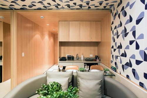 een woonkamer met 2 stoelen en een keuken bij Flat melhor localização Hotel Athos Bulcão in Brasilia