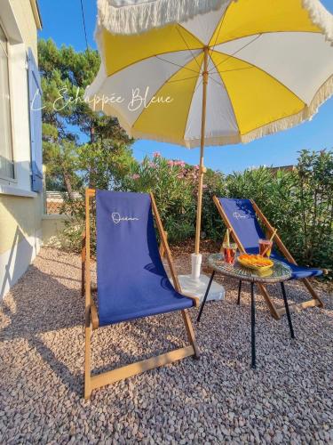 two chairs and a table and an umbrella at L'Échappée Bleue, maison à 200m de la mer pour vacances et travail in Saint-Brevin-les-Pins