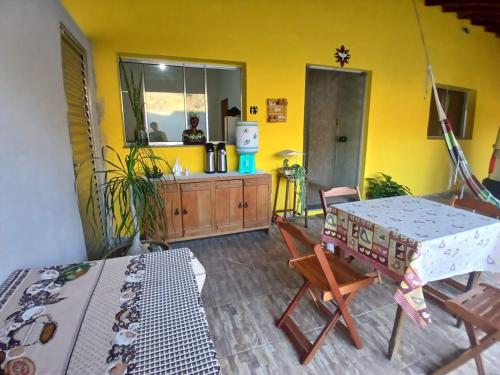 un soggiorno con tavolo e parete gialla di Pousada Imperatriz a Aparecida