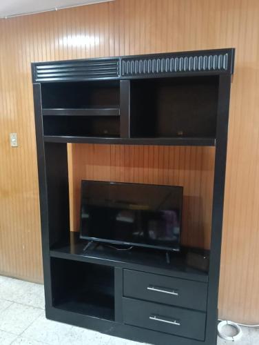 a black entertainment center with a flat screen tv at Departamento 4 Ote in Puebla