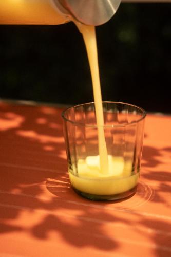 a person pouring milk into a glass on a table at Cholula Condesa Hotel by Lumina in Mexico City