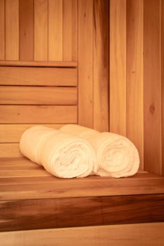 a rolled up towel sitting on a wooden shelf in a sauna at Cholula Condesa Hotel by Lumina in Mexico City