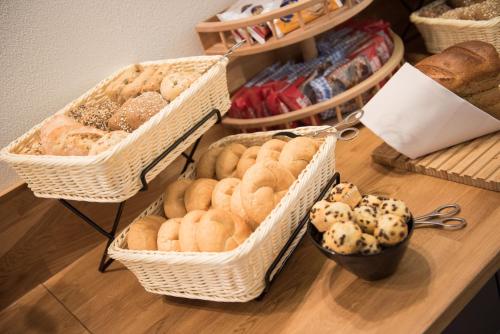 einen Tisch mit Körben verschiedener Brotsorten in der Unterkunft Parkhotel Schillerhain in Kirchheimbolanden