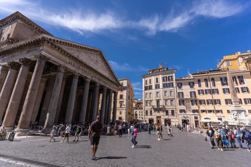 a group of people walking in a city square at AGH Pantheon in Rome