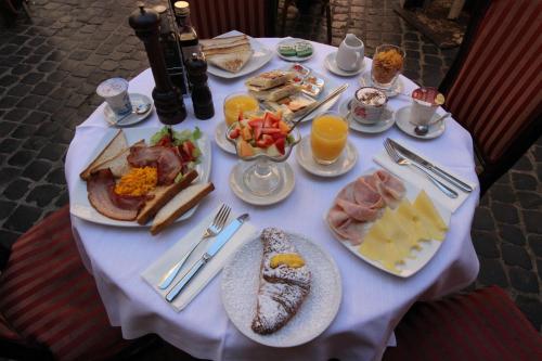 una mesa blanca cubierta con platos de comida y bebida en AGH Pantheon, en Roma