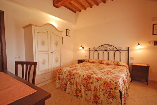 a bedroom with a bed with a floral bedspread at Saturnia Pian Di Cataverna in Saturnia