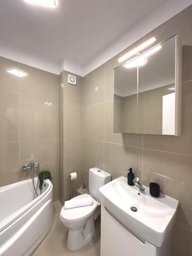 a bathroom with a sink and a toilet and a bath tub at Nivara Nest in Chiajna