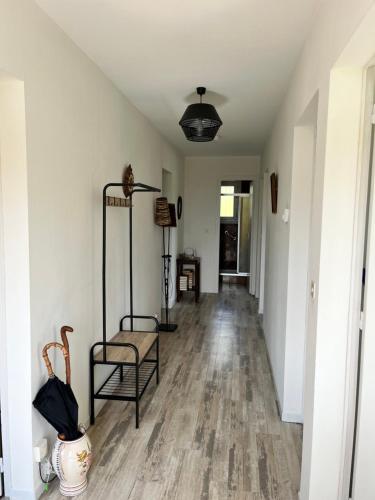 an empty hallway with a table and a chair at Maison BERDOT in Sévignac-Thèze