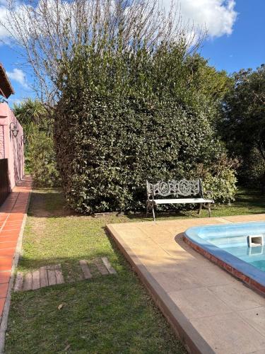 a bench sitting next to a swimming pool at Mini cabaña El Solcito, tranquilidad a dos cuadras de la Laguna de Chascomús in Chascomús