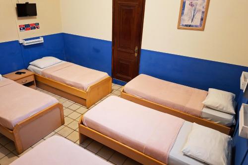 a room with three beds and a tv at Pousada Casa Grande in Bonito