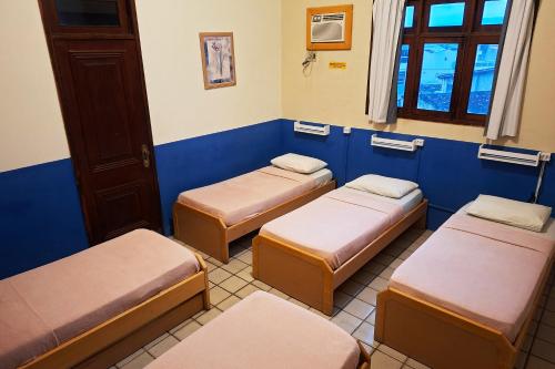 a room with three beds in a room at Pousada Casa Grande in Bonito