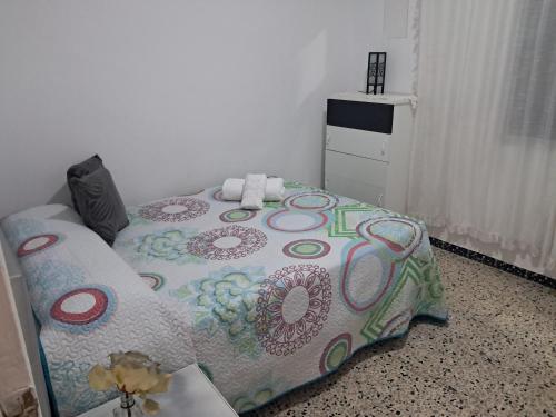 a bedroom with a bed with a flowered blanket at Apartamento Tahalia 3 habitaciones in Huelva