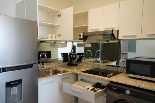 a kitchen with white cabinets and a sink at AmazINN Places Casa Fortaleza in Panama City