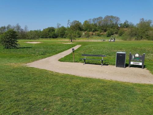 a park with a bench and a path in a field at 8 person holiday home in Skals in Skals