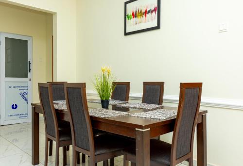 a dining room with a wooden table and chairs at Premium Prestige Apartment in Apenkwa