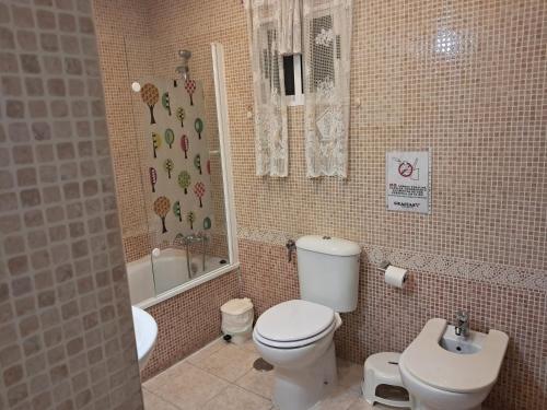 a bathroom with a toilet and a tub and a sink at Apartamento Tahalia 3 habitaciones in Huelva