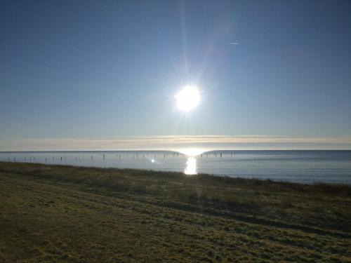 a sun rising over the water with a beach at Luxury Spa Retreat in Lolland - By Traum Ferienwohnungen in Nakskov