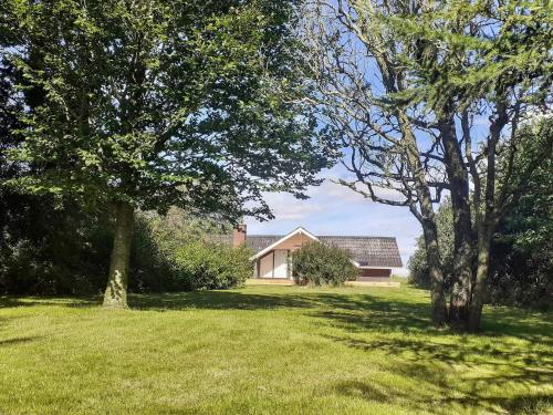 a house in the middle of a yard with trees at Seaside Rustic Retreat - By Traum Ferienwohnungen in Flovtrup