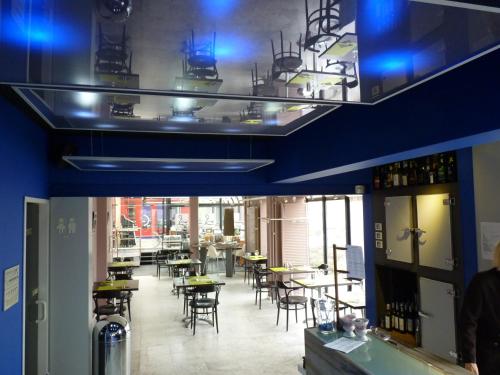 a dining room with tables and chairs and blue ceilings at Hotel De Swaen in Herentals