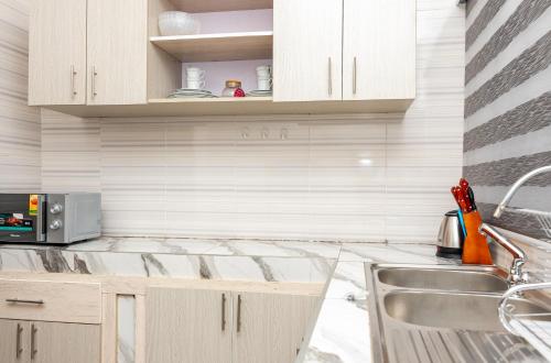 a kitchen with a sink and a microwave at Premium Prestige Apartment in Apenkwa
