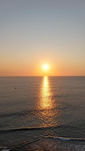 a sunset over the ocean with the sun setting at Coral Cove in Flic-en-Flac