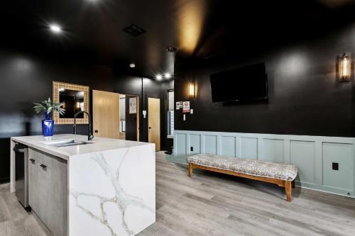 a waiting room with a bench and a tv on a wall at Nova Rooftop Villa in New Orleans