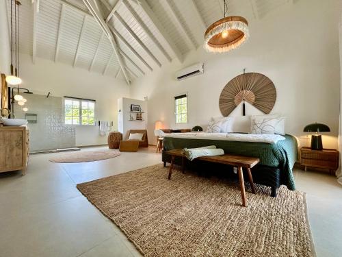 a large bedroom with a bed and a rug at Villa Les Oliviers - Élégance & Sérénité in Les Terres Basses
