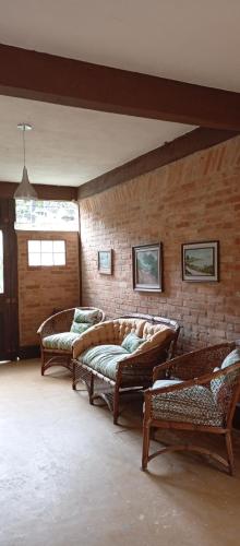 a living room with two couches and a brick wall at Catavento Flats e Suítes in São Sebastião