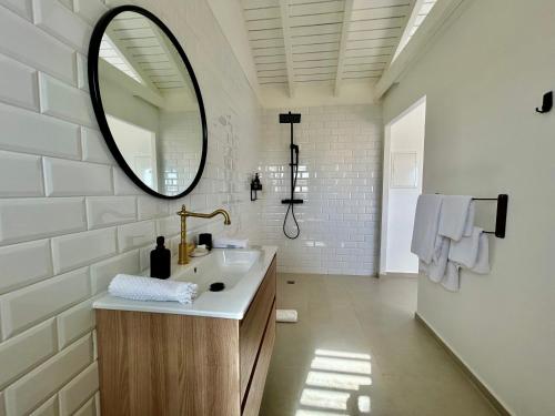 a bathroom with a sink and a mirror at Villa Les Oliviers - Élégance & Sérénité in Les Terres Basses
