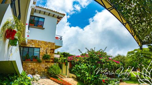 a house with flowers in front of it at Hotel María Isabel Ataco in Concepción de Ataco