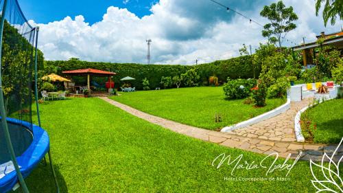 a green yard with a path in the grass at Hotel María Isabel Ataco in Concepción de Ataco