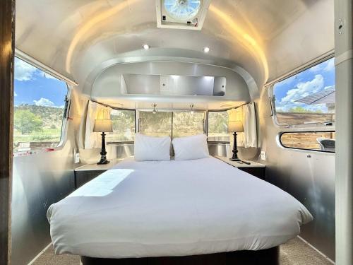 オーダービルにあるThe Airstream 1 at The Fields in East Zionのバンの真ん中にベッドが備わるベッドルーム1室