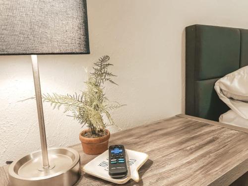 a table with a cell phone and a lamp on it at Affordable Retro Retreat 80s Townhome in Perkins