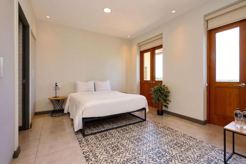 a bedroom with a white bed and a rug at AmazINN Places Casa Fortaleza in Panama City