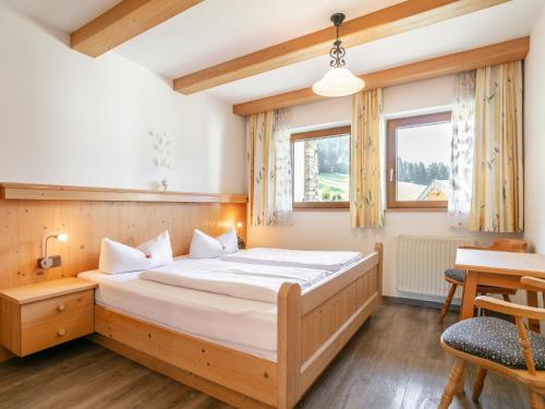 a bedroom with a large bed and a table at Landhaus Marchfeld Top 5 in Wildschönau
