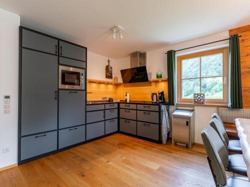 a kitchen with black cabinets and a table and chairs at Sperlingnest in Donnersbachwald