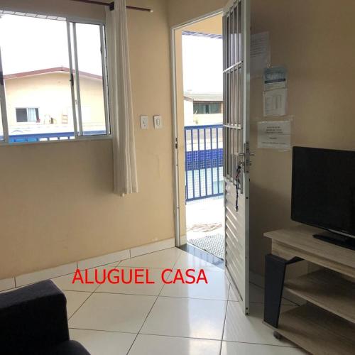 a living room with a sliding door and a television at Pousada do Bene - Aluguel Casa in Guarujá