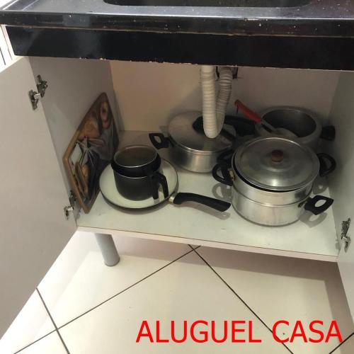 two pots and pans on a stove in a kitchen at Pousada do Bene - Aluguel Casa in Guarujá