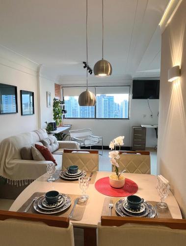 a kitchen and living room with a table and chairs at Flat Parque da Jaqueira in Recife