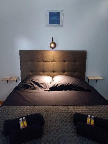 a bedroom with a large bed with a large headboard at "Frangipani" city center room in Papeete