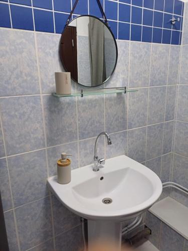 a bathroom with a sink and a mirror at "Frangipani" city center room in Papeete