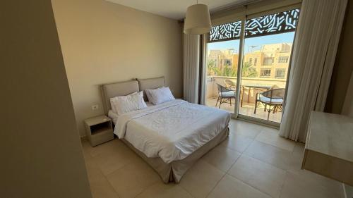 a bedroom with a bed and a balcony with a table at El Gouna Mangroovy M8-3B Sleeps 4 Persons in Hurghada