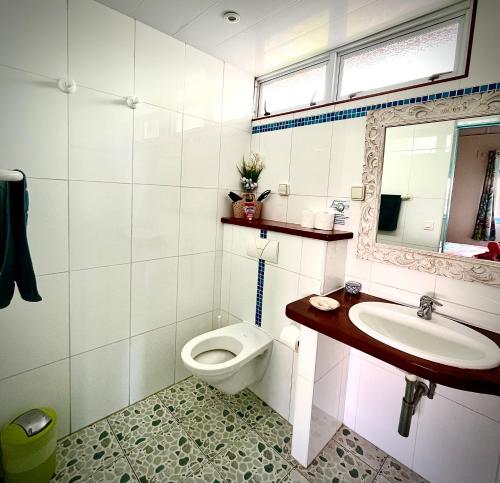 a white bathroom with a toilet and a sink at Linareva Moorea Beach Resort in Haapiti