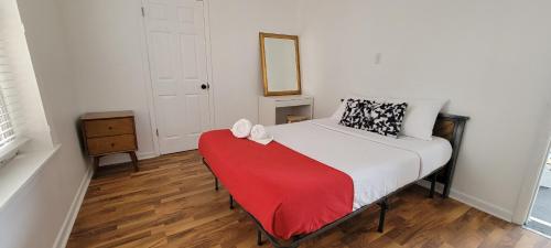 a bedroom with a bed with a red blanket and a mirror at Grand House in Chicago