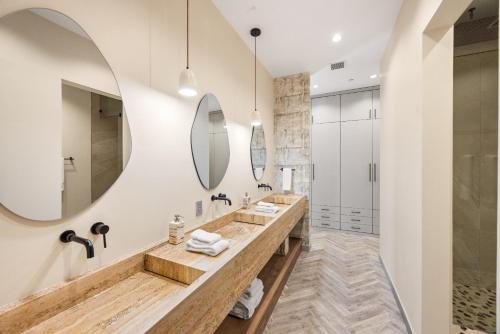 a bathroom with two sinks and two mirrors at The Desert Wellness Compound in Palm Desert