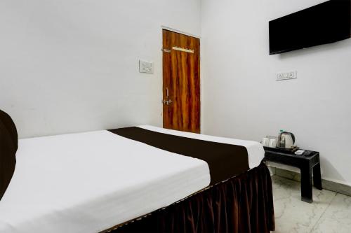 a bedroom with a bed and a television in it at Hotel O Basera Lodging in Nagpur