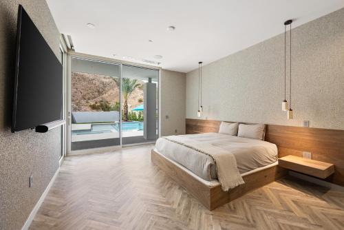 a bedroom with a bed and a large window at The Desert Wellness Compound in Palm Desert