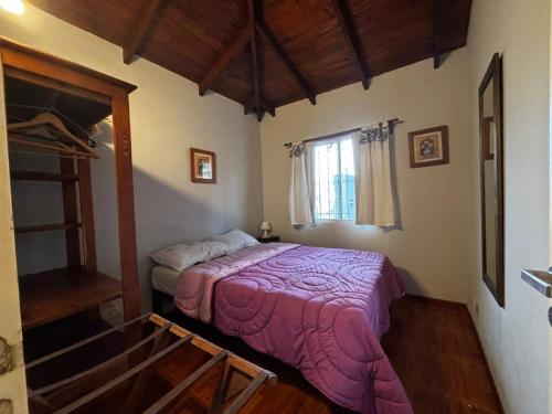 Un dormitorio con una cama con una manta morada. en Family Home en Costa Azul, en Costa Azul